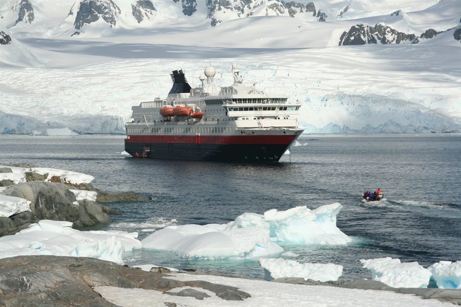Expedition ship and small boat near a glacier